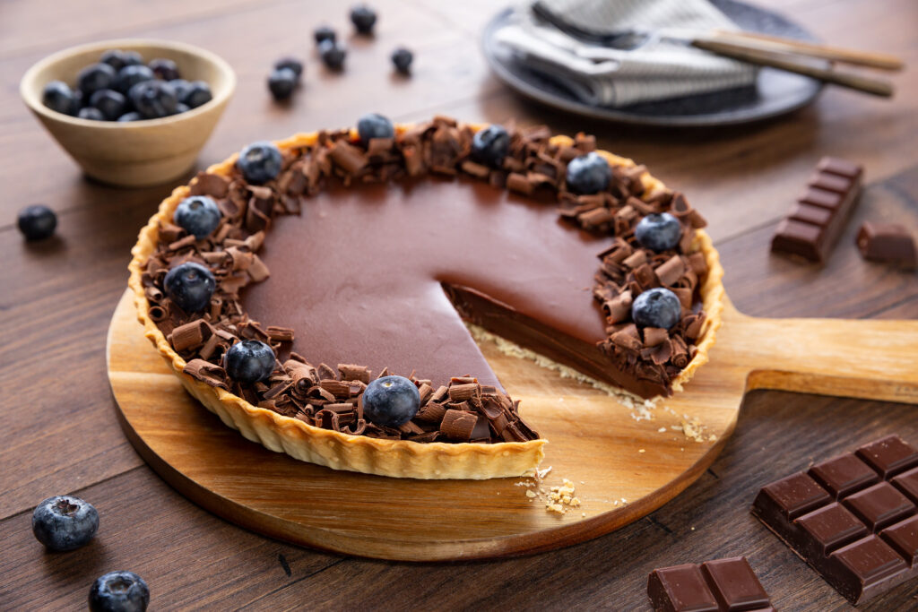 Tartaleta de masa fina rellena de mouse de chocolate y decorada con arándanos