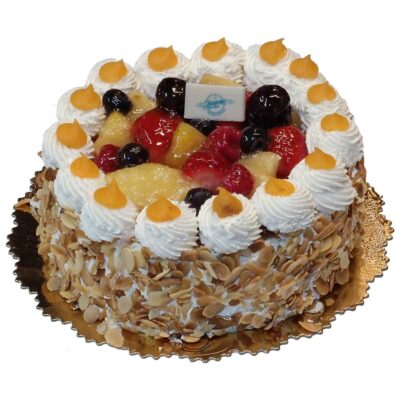 Tarta de bizcocho y nata coronada con distintas frutas en almíbar y almendras