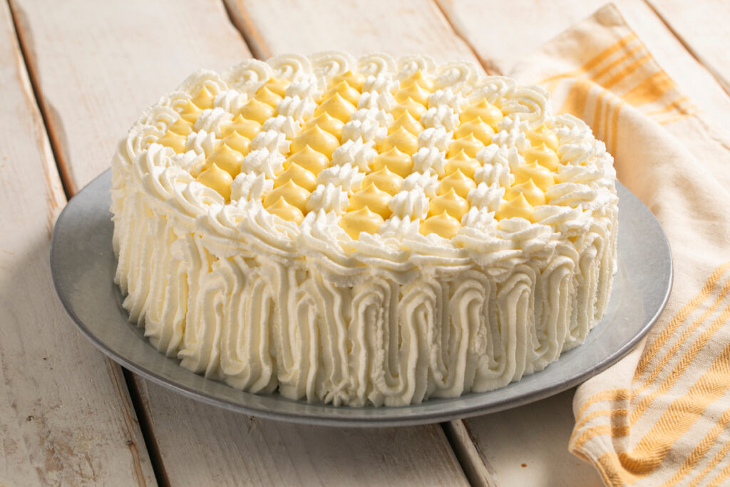 Tarta de bizcocho de limón decorada con chantilly y mouse de limón